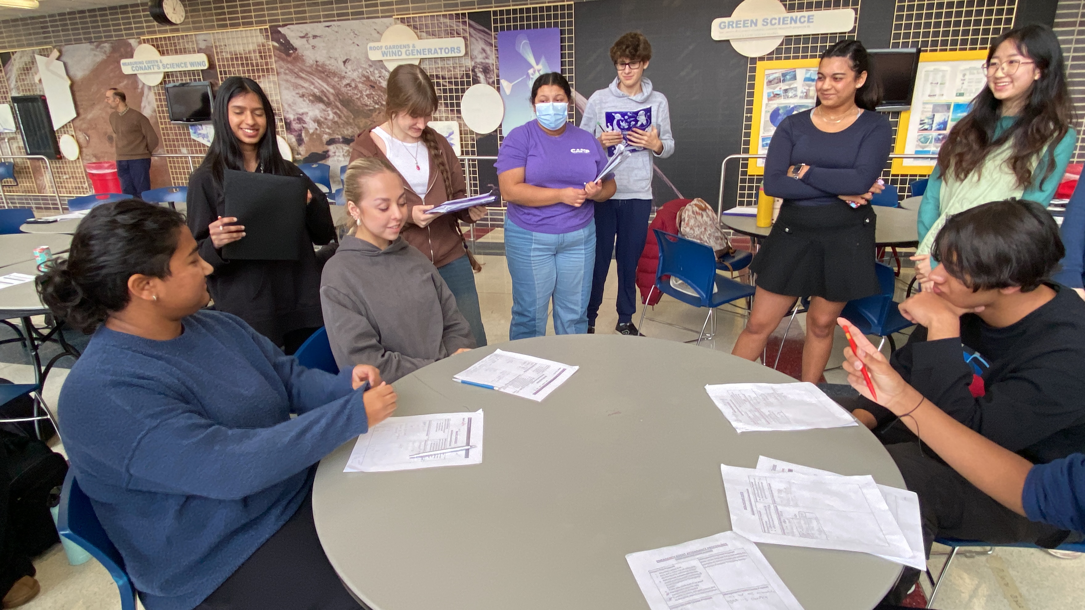 A group of LEC folks and community members standing around a table